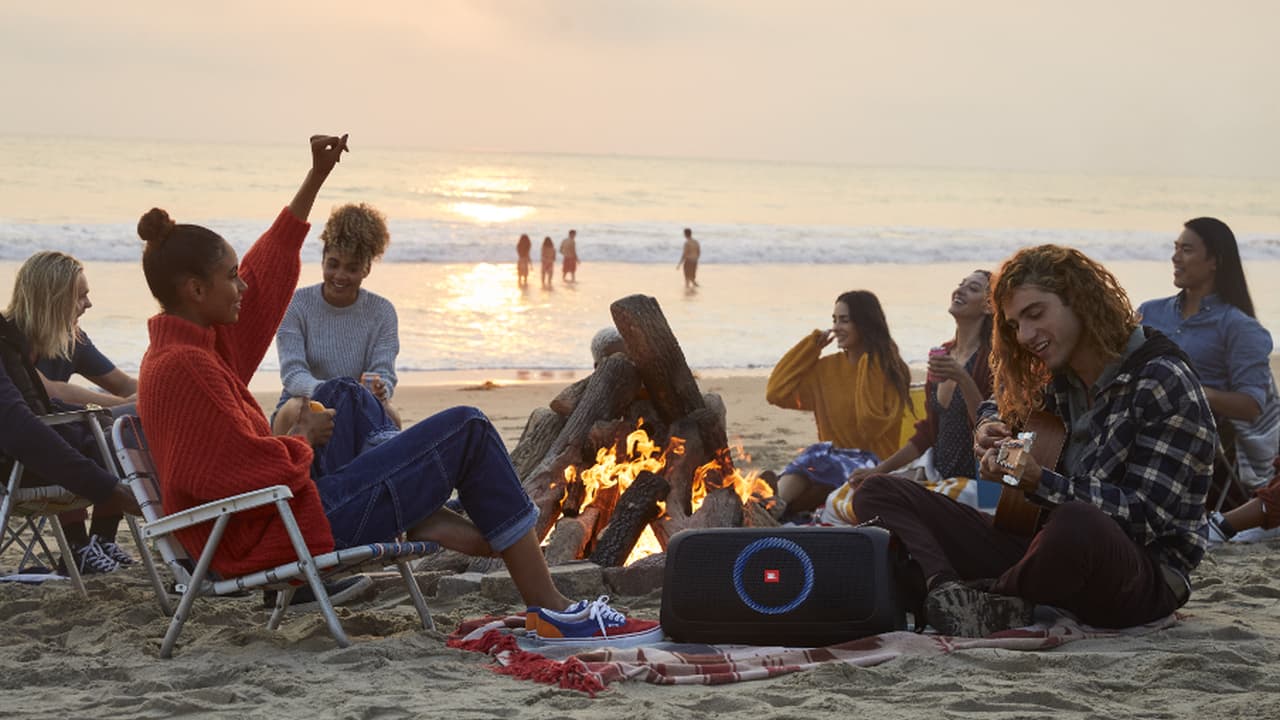 JBL PartyBox On-the-go Portable Bluetooth Speaker on the beach lifestyle